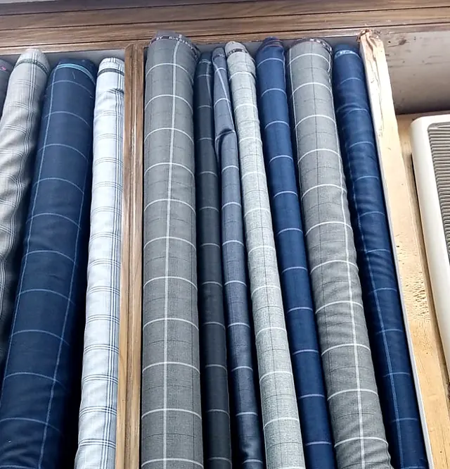 Rolls of grey and blue windowpane check suiting