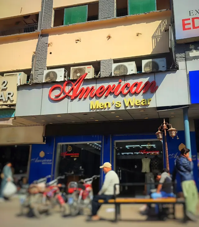 The American Men's Wear shopfront with glass doors and suits on display