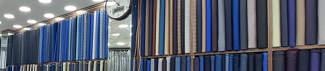 Inside the shop: walls of suiting rolls in blues, greys, browns and darks